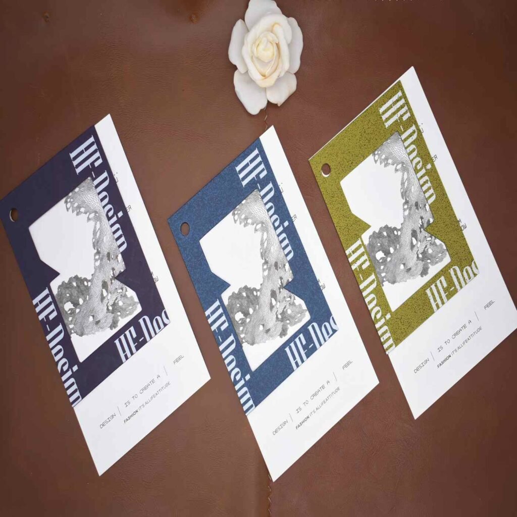 Custom premium embossed clothing hang tags in navy blue and olive green heavy cardstock for luxury designer branding.