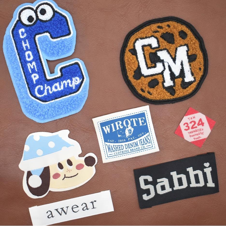Close-up detail of various custom apparel tags and patches showing premium texture.
